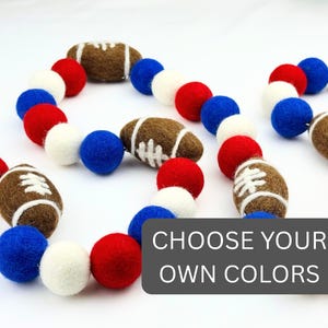 Puede incluir: Una guirnalda de balones de fútbol y bolas de fieltro rojas, blancas y azules. Este artículo decorativo es ideal para fiestas temáticas deportivas o decoración de habitaciones. El texto "CHOOSE YOUR OWN COLORS" es visible.