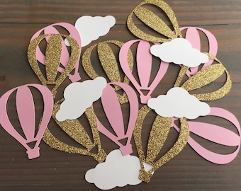 Puede incluir: Recortes de papel de globos aerostáticos rosas y dorados con recortes de nubes blancas. Son decoraciones para una fiesta de baby shower o una fiesta de cumpleaños.