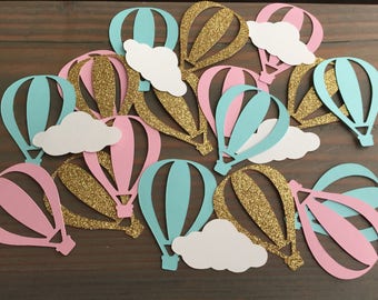 Puede incluir: Una colección de recortes de globos aerostáticos de papel en rosa, azul y dorado con purpurina. Los globos tienen nubes blancas unidas a ellos.