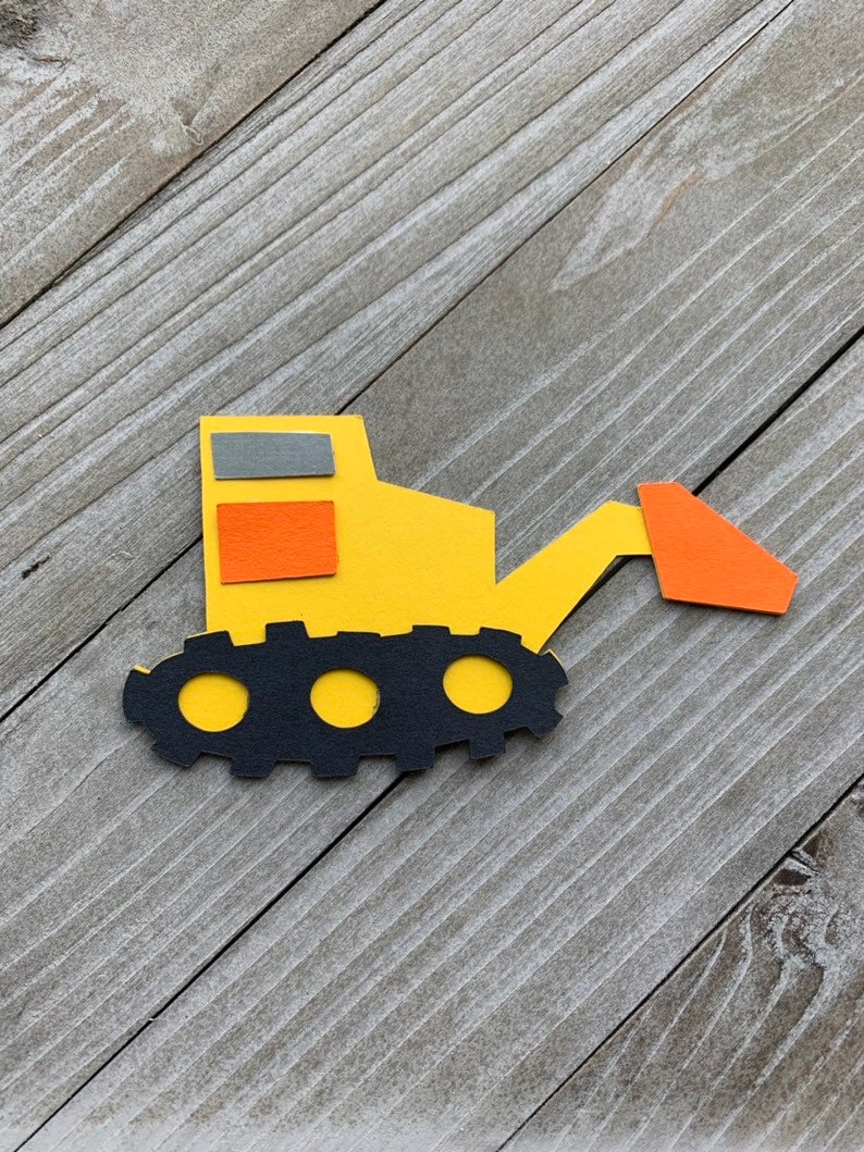 May include: A yellow toy construction vehicle with a black tread, orange and gray windows, and an orange scoop.