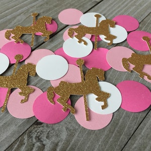 May include: Pink and white paper circles with gold glitter carousel horse cutouts. The horses are facing different directions.