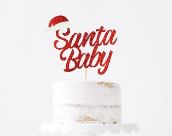 May include: Red glitter cake topper with the words "Santa Baby" and a small Santa hat.