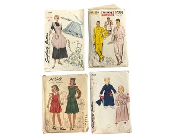 Vintage 1950s patterns: apron, men's pjs, pinafore, kid's gown and toy puppies.