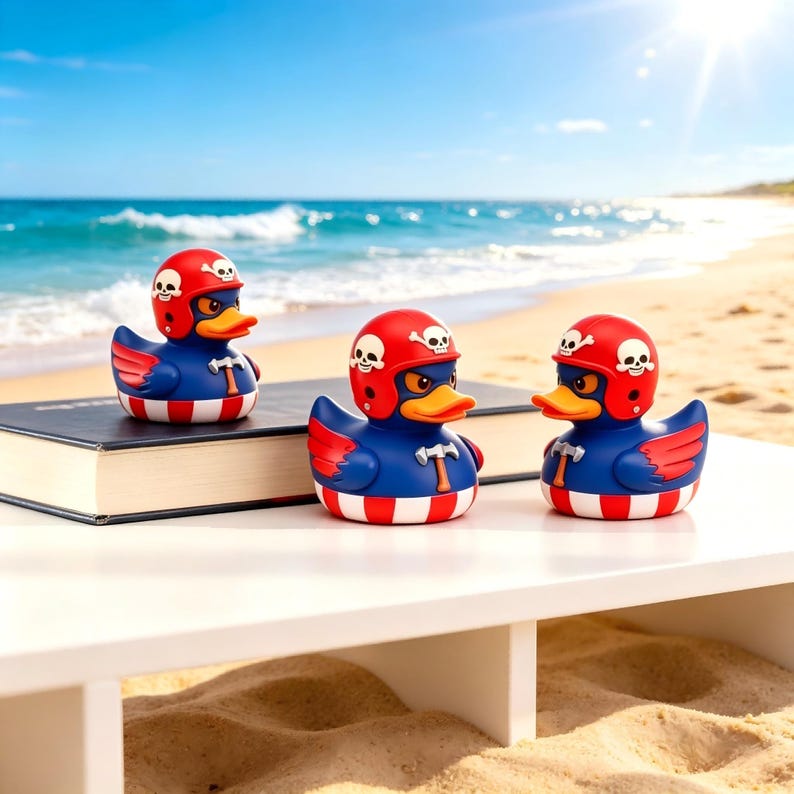 May include: Three rubber ducks with blue bodies, red and white striped bases, and red helmets featuring white skull and crossbones designs. Each duck has a yellow beak, red wings, and a small hammer emblem on its chest, positioned on a black book.