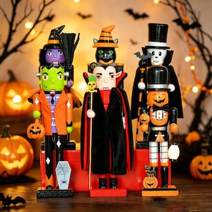May include: A set of five Halloween-themed nutcrackers featuring a green monster, a vampire in a black cape, a skeleton in a top hat, a witch with a broom, and a cat in an orange hat, all standing on a red base with pumpkin accessories.