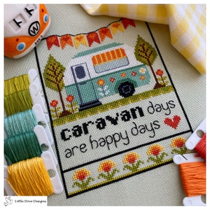 May include: Cross stitch pattern featuring a green and white caravan with a yellow awning, surrounded by flowers and trees. The text reads "Caravan days are happy days" with a red heart.
