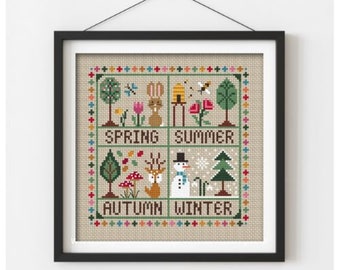 Op de afbeelding: Borduurpatroon met de vier seizoenen: lente met een konijn, zomer met een bijenkorf, herfst met een hert en winter met een sneeuwpop. Elk seizoen is omlijst met een kleurrijke rand en de woorden "Lente", "Zomer", "Herfst" en "Winter" staan onder elke scène.