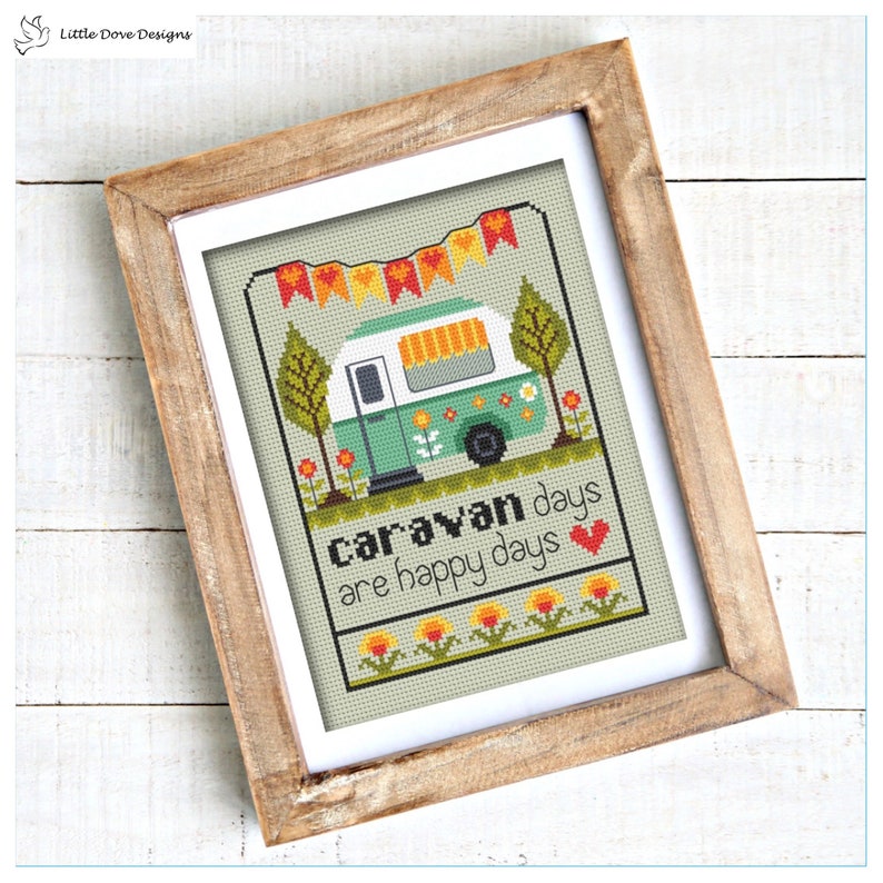 May include: Cross stitch pattern featuring a green caravan with a yellow awning, surrounded by flowers and trees. The text reads "Caravan days are happy days" with a red heart.