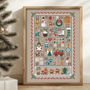 Puede incluir: Calendario de Adviento de punto de cruz enmarcado en un marco de madera. El diseño presenta 25 cuadrados numerados con imágenes navideñas como un muñeco de nieve, un ángel y renos. El texto "Little Dove Designs" está en la parte inferior.