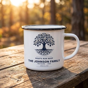 Puede incluir: Una taza de esmalte blanco con borde y asa negros, que presenta un gráfico de árbol azul oscuro con raíces. El texto dice: ROOTS RUN DEEP, THE JOHNSON FAMILY, REUNION 2026, Atlanta, GA. El diseño está centrado en la parte frontal de la taza.