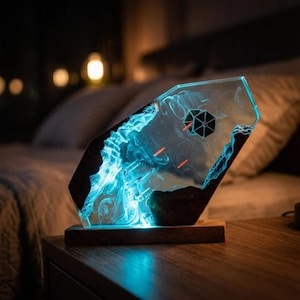 Könnte beinhalten: Eine sechseckige Harz- und Holzlampe mit leuchtendem blauem Nebeleffekt. Im Inneren des klaren Harzes sind ein Miniatur-Sternenjäger und ein TIE-Jäger mit roten Laserstrahlen positioniert, montiert auf einem rechteckigen Holzsockel mit Innenbeleuchtung.