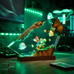 May include: A decorative resin and wood lamp featuring a miniature Mario riding Yoshi, a white Boo ghost, floating gold coins, a question mark block, and a small star. The scene is encased in a clear, angular resin block with natural wood edges.