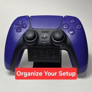 Könnte beinhalten: Ein violetter und schwarzer kabelloser Videospiel-Controller auf einem schwarzen Ständer mit dem eingeprägten Text DP3D auf der Vorderseite. Ein rotes rechteckiges Etikett unten zeigt den weißen Text Organize Your Setup in serifenloser Schrift.