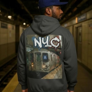 May include: A dark gray hooded sweatshirt featuring a large back graphic of a subway train in a station with the text NYC in white graffiti-style lettering above the train. The train has a blue A sign on the front and illuminated headlights.