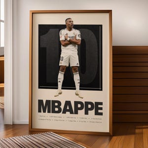 May include: A framed poster featuring a footballer in a white kit with arms crossed, standing in front of a large black number 10. The text MBAPPE is printed below, followed by a list of achievements including World Cup and UEFA titles.