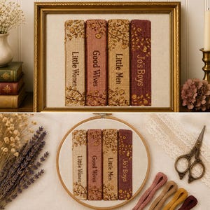 May include: A needlepoint embroidery featuring four book spines titled Little Women, Good Wives, Little Men, and Jo's Boys, displayed in a gold frame and a circular wooden hoop, showcasing floral patterns in shades of beige, pink, and maroon.