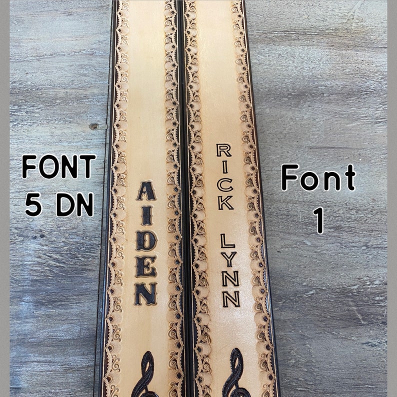 Pu&ograve; includere: Due cinturini in pelle con cuciture decorative e un design a nota musicale. I cinturini sono personalizzati con i nomi "Aiden" e "Rick Lynn" in diversi caratteri. Il testo "Font 5 DN" e "Font 1" &egrave; anche visibile.