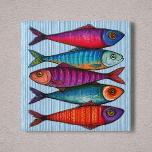 May include: A square wall art print featuring five stacked fish illustrations against a light blue and white vertical striped background. The fish are rendered in vibrant, saturated colors including magenta, teal, purple, orange, and red.
