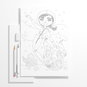 Puede incluir: Dibujo lineal en blanco y negro de una sirena con una chaqueta con capucha, con una cola fluida y burbujas. El dibujo está sobre una hoja de papel blanco, con lápices y una goma de borrar a la izquierda.