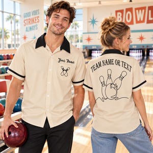 May include: A beige short-sleeve button-down bowling shirt with a black collar and sleeve trim. The front features a pocket with the text Your Name and a bowling pin graphic. The back displays the text TEAM NAME OR TEXT with a bowling graphic.