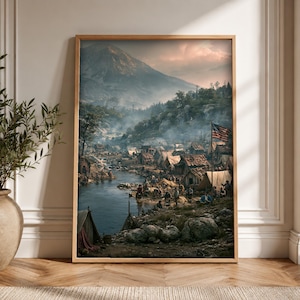 Op de afbeelding: Een ingelijste kunstdruk met een historisch kampement met houten bouwwerken en tenten langs een rivieroever. Een vlag van de Verenigde Staten wappert nabij het midden, met een groot, mistig gebergte dat oprijst in de achtergrond.