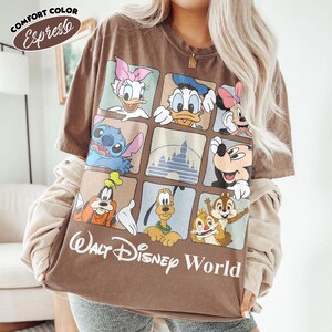 Puede incluir: Una camiseta de manga corta color marr&oacute;n espresso con una cuadr&iacute;cula de nueve cuadrados que muestra personajes de Disney como Daisy, Donald, Minnie, Stitch, Mickey, Goofy, Pluto, Chip y Chop, y un castillo. El texto Walt Disney World aparece debajo.