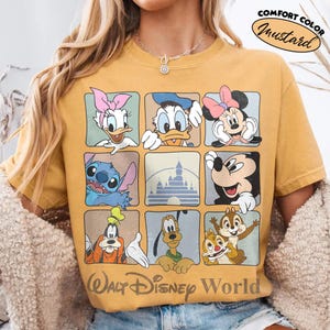 Puede incluir: Una camiseta color amarillo mostaza con una cuadr&iacute;cula de nueve cuadrados que muestra personajes de Disney como Daisy, Donald, Minnie, Stitch, Mickey, Goofy, Pluto y Chip y Dale, adem&aacute;s de un castillo y el texto Walt Disney World.