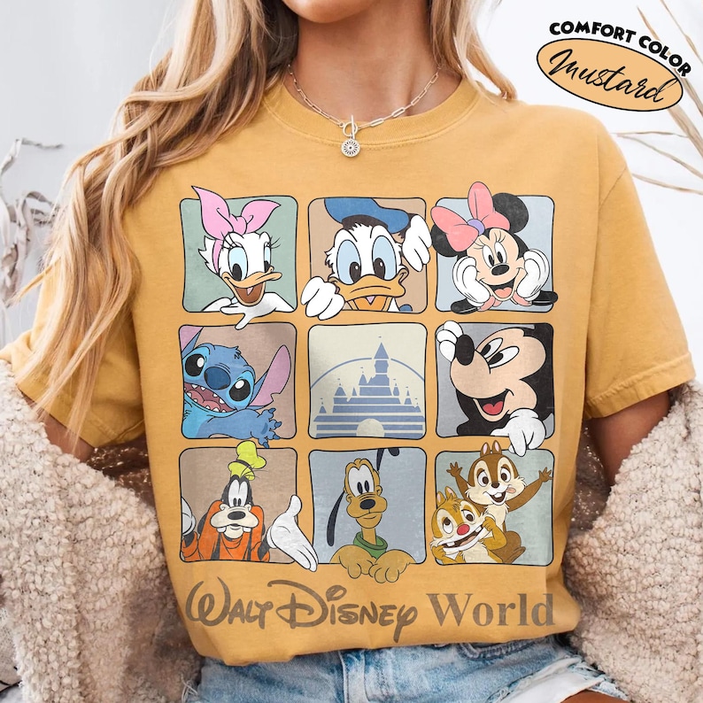 Puede incluir: Una camiseta color amarillo mostaza con una cuadr&iacute;cula de nueve cuadrados que muestra personajes de Disney como Daisy, Donald, Minnie, Stitch, Mickey, Goofy, Pluto y Chip y Dale, adem&aacute;s de un castillo y el texto Walt Disney World.