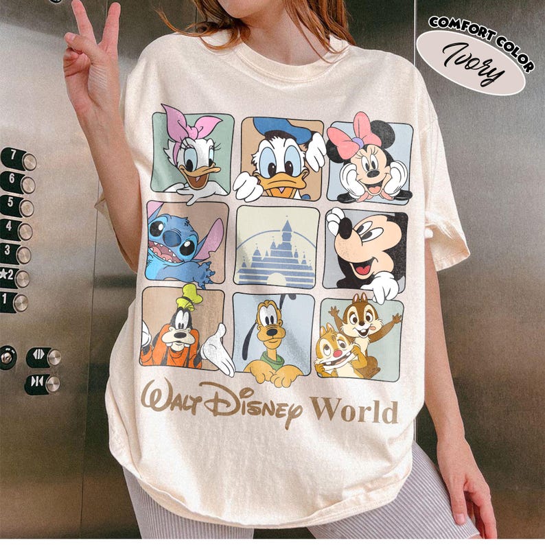 Puede incluir: Una camiseta de color marfil con una cuadr&iacute;cula de nueve cuadrados que muestra personajes de Disney, incluyendo a Daisy, el Pato Donald, Minnie Mouse, Stitch, una silueta de castillo, Mickey Mouse, Goofy, Pluto y Chip y Chop, con el texto Walt Disney World.