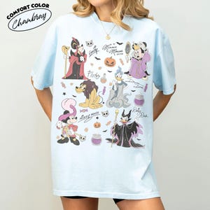 May include: A light blue short-sleeve t-shirt featuring a graphic print of various Disney characters in Halloween costumes, including Mickey Mouse, Minnie Mouse, Donald Duck, Goofy, Pluto, and Daisy Duck, along with small icons like pumpkins and candy.