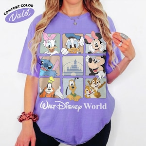 Puede incluir: Una camiseta violeta de manga corta con una cuadr&iacute;cula de nueve cuadrados que muestra personajes de Disney como Daisy, Donald, Minnie, Stitch, la silueta de un castillo, Mickey, Goofy, Pluto y Chip y Dale, junto al texto Walt Disney World.