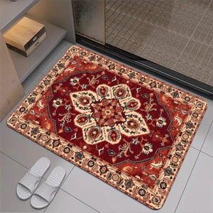 May include: A rectangular floor mat featuring a deep red background with a central cream-colored floral medallion and intricate botanical patterns. The border displays a repeating geometric and floral design in shades of cream, blue, and red.