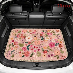 May include: A rectangular car trunk mat featuring a light pink background with a dense, colorful floral pattern of daisies, poppies, and various green leaves. The mat has a decorative border and the text 2D FLAT is visible in the upper right corner.