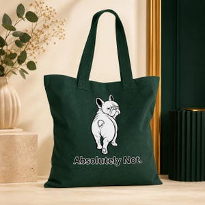 Peut inclure: Un sac fourre-tout vert foncé orné d'une illustration graphique blanche représentant un bouledogue français regardant par-dessus son épaule. Sous le chien, le texte "Absolutely Not." est imprimé en lettres blanches grasses. Sac à deux anses.