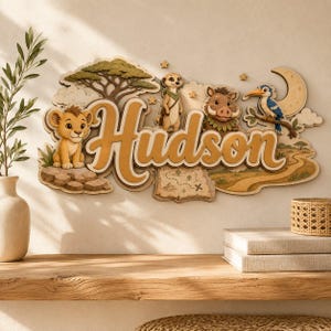 May include: A layered wooden wall sign featuring the name Hudson in large script lettering. The design includes a lion cub, a meerkat, a warthog, and a bird perched on a crescent moon, set against a savanna landscape with a map and acacia tree.