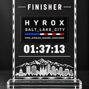 May include: A clear rectangular acrylic award plaque featuring the text FINISHER, a black rectangular patch with HYROX SALT_LAKE_CITY, a red, white, and blue stripe, the text OPEN_SINGLES_SEASON_2025/2026, the time 01:37:13, and a white mountain skyline graphic.