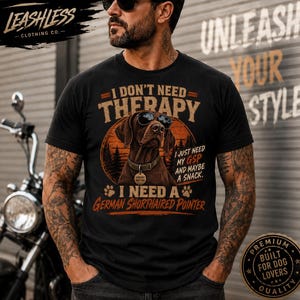 May include: A black t-shirt featuring a graphic of a German Shorthaired Pointer wearing sunglasses. The text reads: I DON'T NEED THERAPY I JUST NEED MY GSP AND MAYBE A SNACK. I NEED A GERMAN SHORTHAIRED POINTER. The dog wears a collar with a tag.