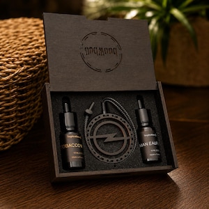 Peut inclure: Un coffret cadeau en bois foncé contenant deux flacons compte-gouttes en verre de 10 ml étiquetés Tobacco et Man Eau, ainsi qu'un pendentif circulaire en bois avec une découpe en forme d'éclair sur un cordon. Le couvercle porte le logo Pnqmoon.