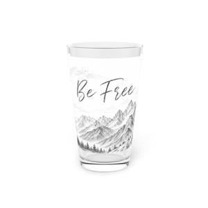 Könnte beinhalten: Ein klares Glas mit einem Berglandschaftsdesign in Schwarz-Weiß und dem Schriftzug "Be Free". Die Illustration zeigt detaillierte Bergspitzen, Bäume und Wolken und schafft eine von der Natur inspirierte Ästhetik.