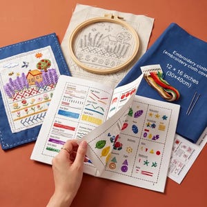 Può includere: Un kit da ricamo che include un telaio in legno con un disegno di una casa stampato, un panno ricamato finito, un pezzo di tessuto blu con l'etichetta 30 x 40 cm, fili da ricamo colorati, due aghi e un libretto di istruzioni con guide ai punti.