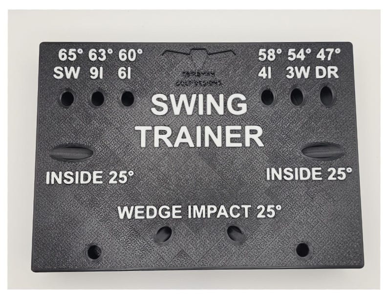 May include: A black rectangular golf swing trainer board with a textured surface. It features white printed text including SWING TRAINER, WEDGE IMPACT 25&deg;, INSIDE 25&deg;, and various degree markings like 65&deg;, 63&deg;, 60&deg;, 58&deg;, 54&deg;, 47&deg; with corresponding club labels.
