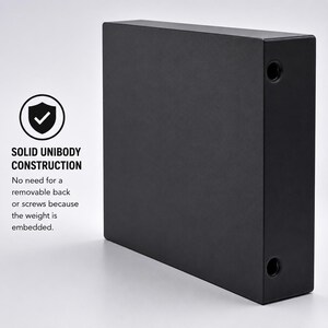 May include: A rectangular black object with a solid unibody construction, featuring two circular openings on the side. Text on the image reads: SOLID UNIBODY CONSTRUCTION. No need for a removable back or screws because the weight is embedded.