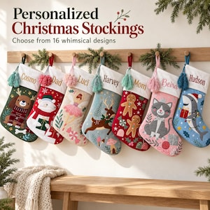 Peut inclure: Sept chaussettes de Noël personnalisées suspendues sur un support en bois. Chaque chaussette présente un revers blanc avec un nom brodé en écriture cursive et un motif unique, incluant un chien, un ours polaire, une fée, un cerf, un bonhomme en pain d'épice, un chat et un requin.