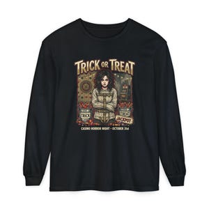May include: A black long-sleeve t-shirt featuring a graphic of a person in a straightjacket between two buckets of candy. The text reads TRICK OR TREAT, TREAT JACKPOT, and CASINO HORROR NIGHT - OCTOBER 31ST, with casino-themed background elements.