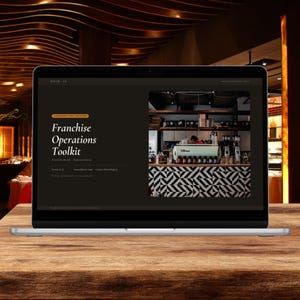 Könnte beinhalten: Ein Laptop-Bildschirm zeigt ein digitales Dokument mit dem Titel Franchise Operations Toolkit. Die Benutzeroberfläche hat einen dunkelbraunen Hintergrund mit weißem Text und ein Foto einer Kaffeetheke mit einer hellgrünen Espressomaschine.