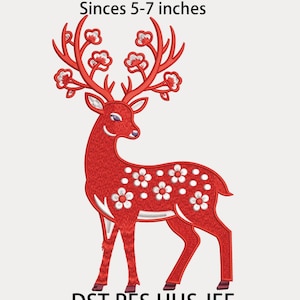 May include: A red deer embroidery design with white floral accents and antlers adorned with white flowers. The text "Sinces 5-7 inches" is above the deer, and "DST PES HUS JEF" is below. The design is suitable for embroidery projects.