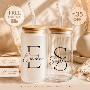 May include: Two glass tumblers with bamboo lids and clear glass straws. One tumbler is frosted glass with the letter E and the name Emma in black text. The other is clear glass with the letter S and the name Sophia in black text. Both feature a cylindrical shape.