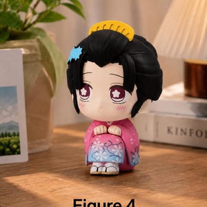 Puede incluir: Peque&ntilde;a figura de un personaje con cabello negro, un peine amarillo y un accesorio azul para el cabello. La figura lleva un kimono rosa con estampados florales. El texto "Figure 4" est&aacute; debajo.