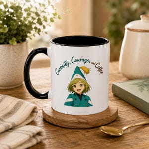 May include: A white ceramic mug with a black interior and handle. The front features a cartoon illustration of a person with green hair wearing a green hat and robe, with the text "Curiosity, Courage, and Coffee" printed in dark green script above.