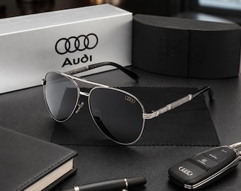 Questi occhiali da sole aviator retrò con doppio ponte e logo Audi presentano lenti polarizzate in metallo lucido.